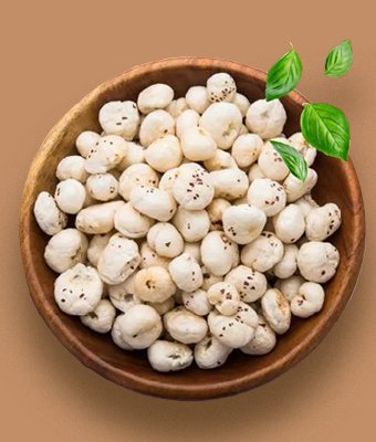 A wooden bowl of popped makhana with green leaves